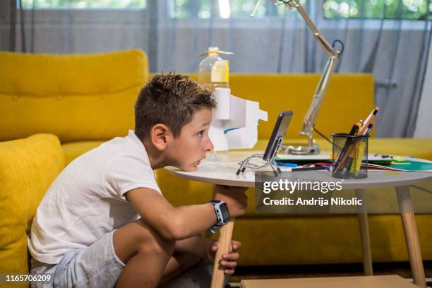 concentrated boy is watching tutorial how to make diy toy - watching youtube stock pictures, royalty-free photos & images