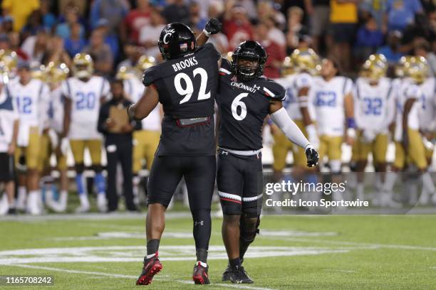 Cincinnati Bearcats defensive tackle Curtis Brooks reacts with teammate Perry Young during the game against the UCLA Bruins and the Cincinnati...