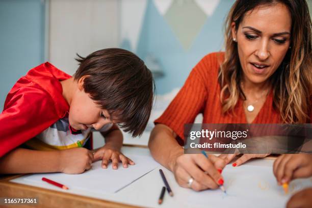 happy mother coloring with her children - superman reveal stock pictures, royalty-free photos & images