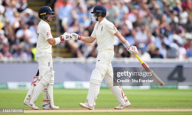 England batsmen Rory Burns and Joe Root fist pump during their partnership during day two of the First Specsavers Test Match between England and...
