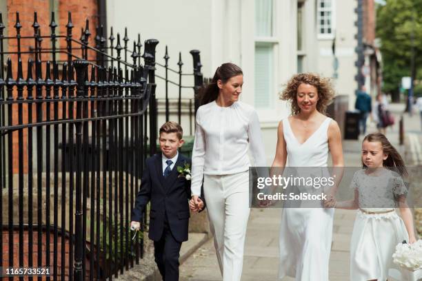 familienspaziergang zum standesamt - hochzeitspaar stock-fotos und bilder