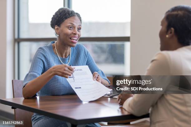 senior female personal banker shows client account application - representing stock pictures, royalty-free photos & images