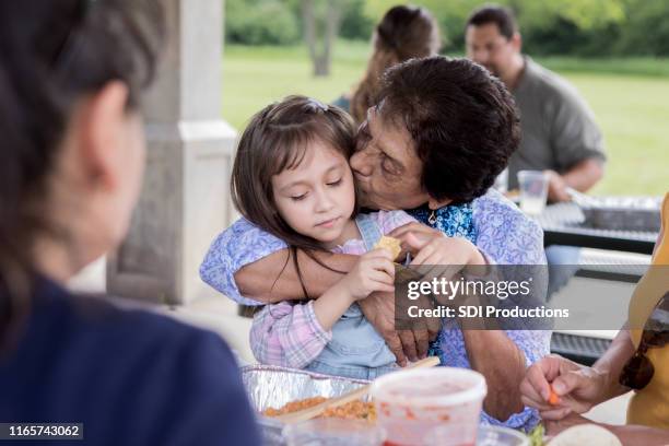 grandma kisses granddaughter's cheek - big family dinner stock pictures, royalty-free photos & images