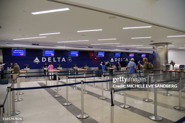 Passengers wait to talk to counter officals at Delta airlines at Fort Lauderdale-Hollywood International Airport in Fort Lauderdale, Florida on...