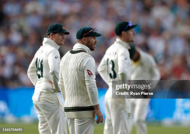 David Warner, Cameron Bancroft and Steve Smith of Australia look on as the England supporters sing songs related to their ball tampering ban during...