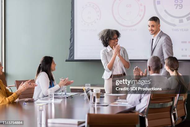 businesswoman introduces guest speaker - guest speaker stock pictures, royalty-free photos & images