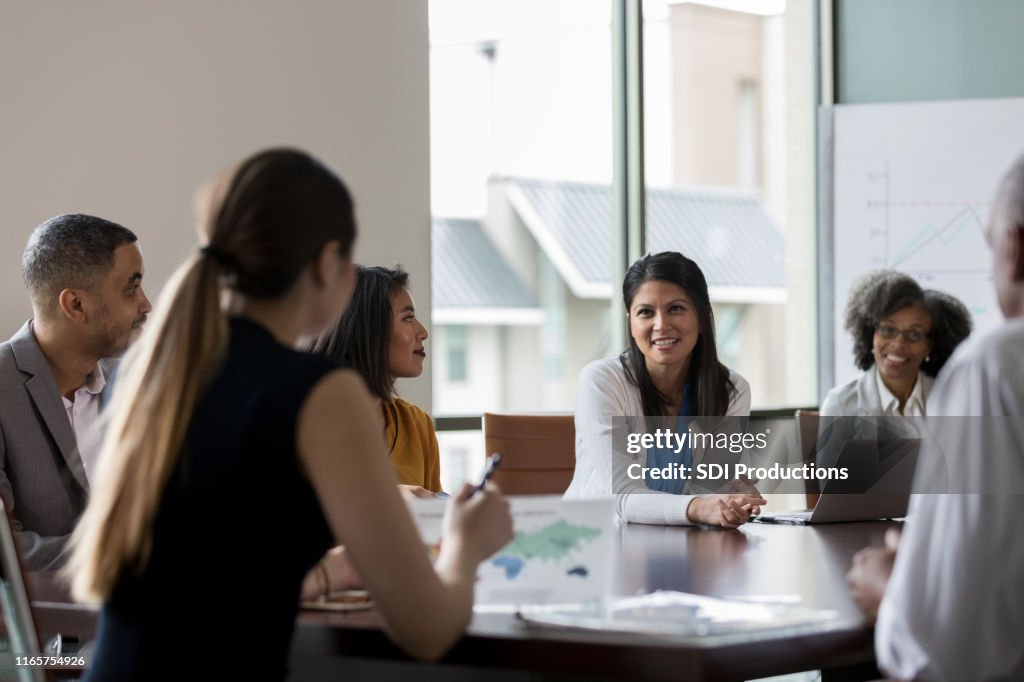 Mid adult woman talks during meeting