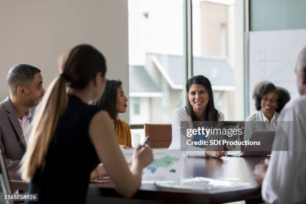 mid adult woman talks during meeting - governing board stock pictures, royalty-free photos & images