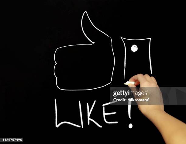 hand drawing thumbs up with chalk in black board - loneliness icon stock pictures, royalty-free photos & images