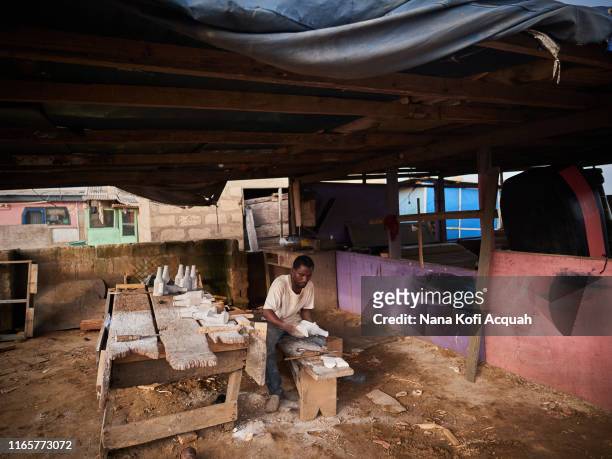 David Hugo works on a miniature beer club fantasy coffin model in his workshop on June 24, 2019 in La Accra, Ghana. Among residents of Accra, the...