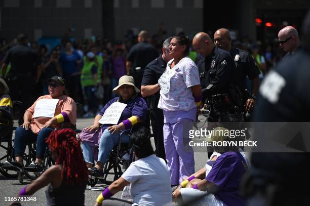 Demonstrator is arrested during a civil disobedience action by Kaiser Permanente healthcare workers, patients during a Labor Day protest, September...