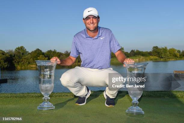 Scottie Scheffler poses with trophies for Finals Points Leader and Regular Season Points Leader on the 18th green after the final round of the Korn...