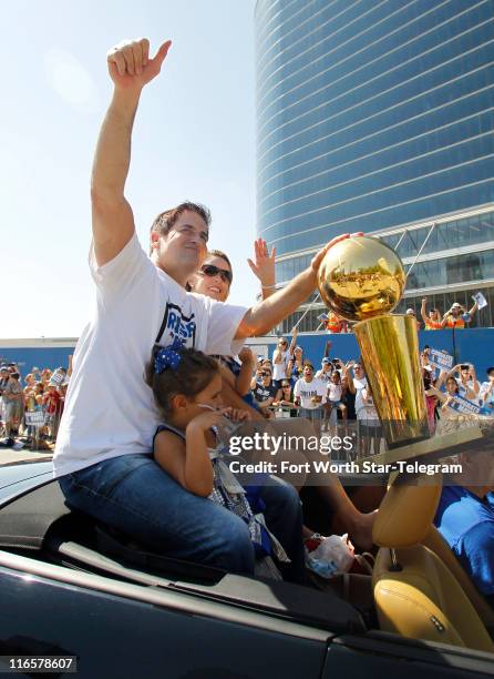 Dallas Mavericks owner Mark Cuban rides with the NBA Championship trophy during the Dallas Mavericks victory parade through downtown Dallas, Texas,...