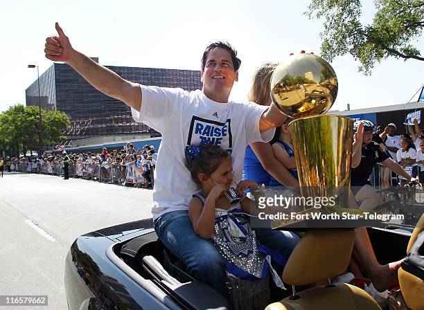 Dallas Mavericks owner Mark Cuban rides with the NBA Championship trophy during the Dallas Mavericks victory parade through downtown Dallas, Texas,...