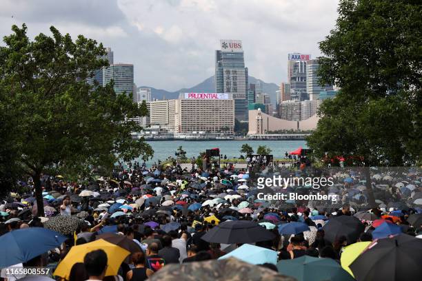 Demonstrators sit under umbrellas during a strike rally at Tamar Park in the Admiralty district of Hong Kong, China, on Tuesday, Sept. 3, 2019. Hong...