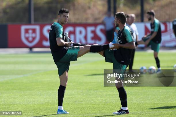 Portugal's forward Cristiano Ronaldo and defender Daniel Carrico warm up during a training session at Cidade do Futebol training camp in Oeiras,...