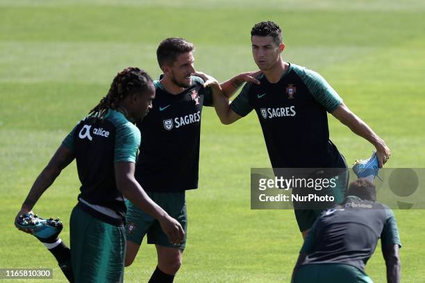 Portugal's forward Cristiano Ronaldo warms up with teammates during a training session at Cidade do Futebol training camp in Oeiras, outskirts of...