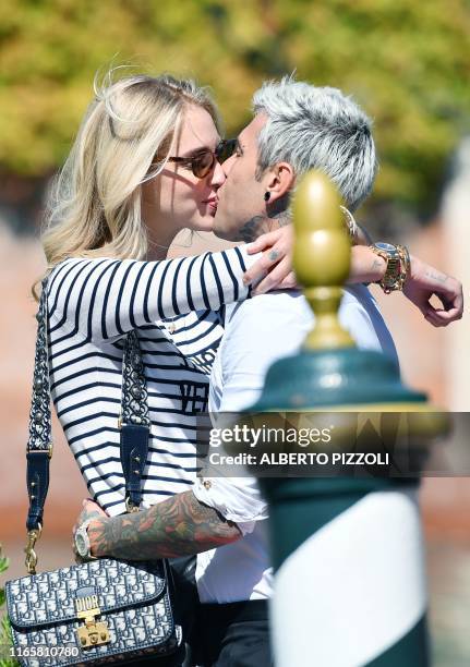 Italian fashion blogger and designer Chiara Ferragni embraces and kisses her husband Italian rapper Federico Leonardo Lucia aka Fedez upon their...