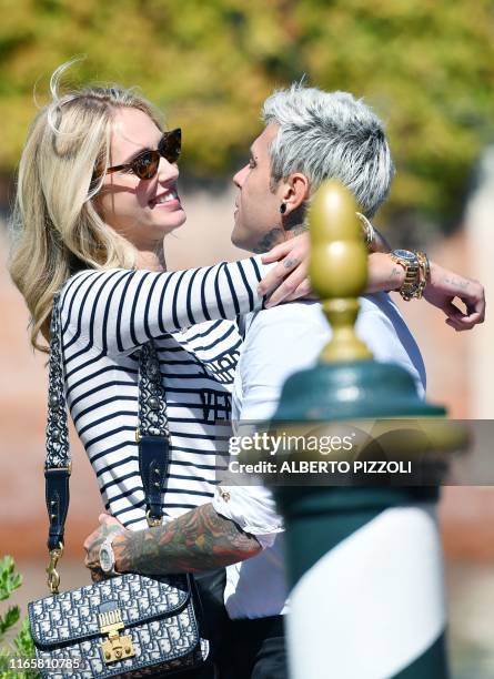 Italian fashion blogger and designer Chiara Ferragni embraces her husband Italian rapper Federico Leonardo Lucia aka Fedez upon their arrival at the...