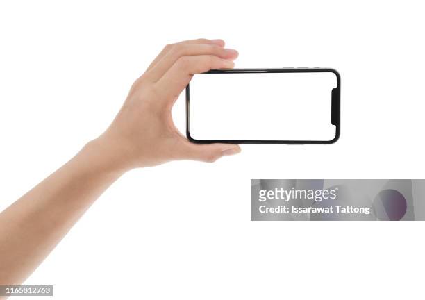 close up hand hold phone isolated on white, mock-up smartphone white color blank screen - hand holding phone stockfoto's en -beelden