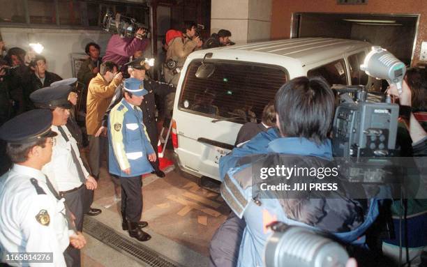 Surrounded by cameramen, a police vehicle carrying a body of ruling Liberal Democratic Party's lawmaker Shokei Arai, enters a police station in Tokyo...