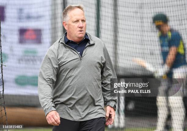 Former Australia wicket keeper and batsman Ian Healy bowls at Australia's captain Tim Paine in the nets during a training session at Old Trafford in...