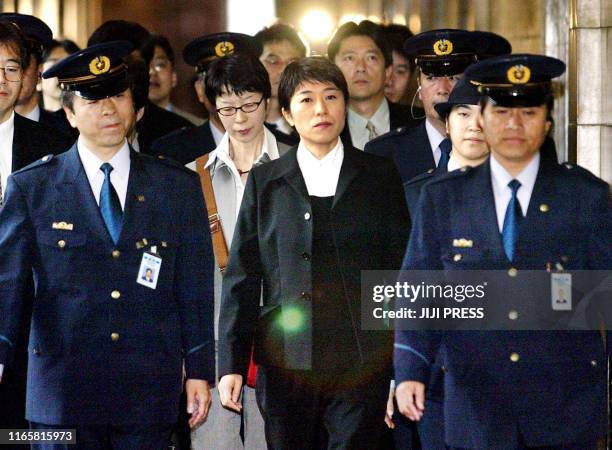 Former opposition lawmaker Kiyomi Tsujimoto , surrounded by Diet guards, enters the Diet building to testify at the Lower House's budget committee...