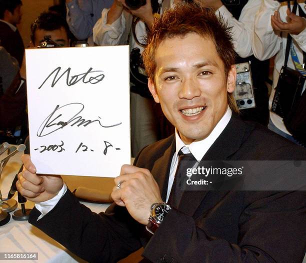 Japanese baseball star Kazuo Matsui shows his autograph after agreeing to join the New York Mets for three years during a press conference in Narita...