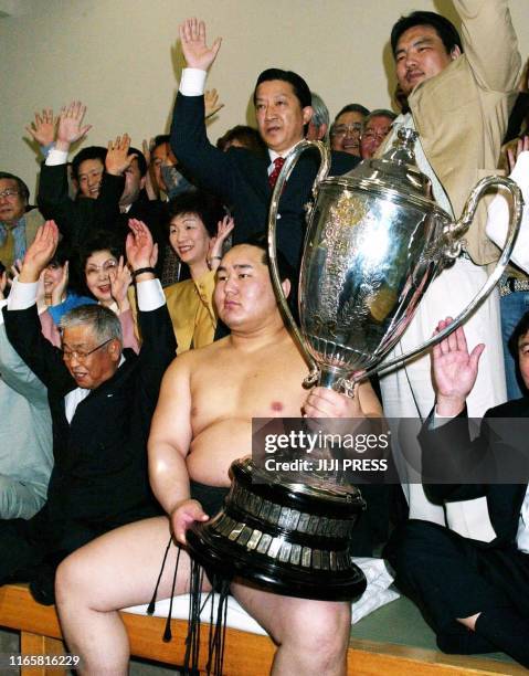 Mongolian Yokozuna Asashoryu holds the Emperor's Cup trophy among his supporters jubilating after winning the Summer Grand Sumo Tournament in Tokyo,...
