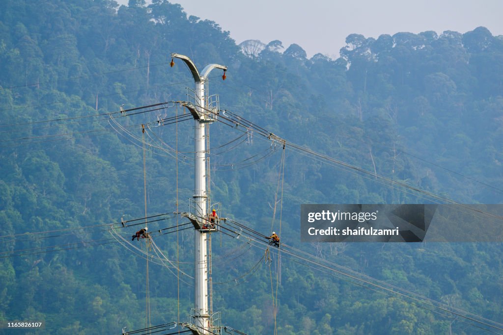 Workers working on power pole at sub urban area of Kuala Lumpur, Malaysia.