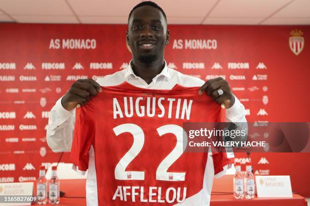 Monaco's French forward Jean-Kevin Augustin poses with his jersey after a press conference held for his presentation in La Turbie, near Monaco on...