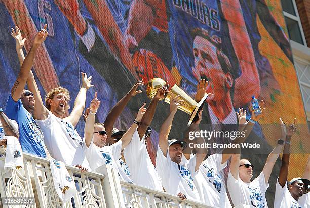 Guard Jason Kidd of the Dallas Mavericks hoists the Larry O'Brien Trophy from the American Airlines Center balcony for fans gathered at Victory Plaza...
