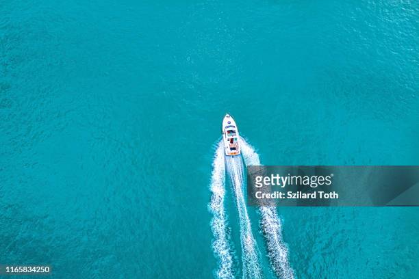 speed boat on  azure sea in turquoise blue water -  birdseye aerial view of boat - motor boat photos et images de collection