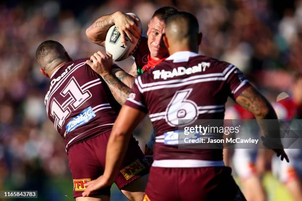 Shaun Kenny-Dowall of the Knights is tackled during the round 20 NRL match between the Manly Sea Eagles and the Newcastle Knights at Lottoland on...