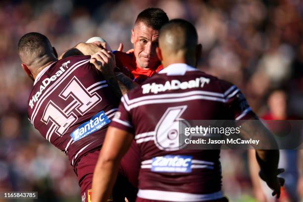 Shaun Kenny-Dowall of the Knights is tackled during the round 20 NRL match between the Manly Sea Eagles and the Newcastle Knights at Lottoland on...