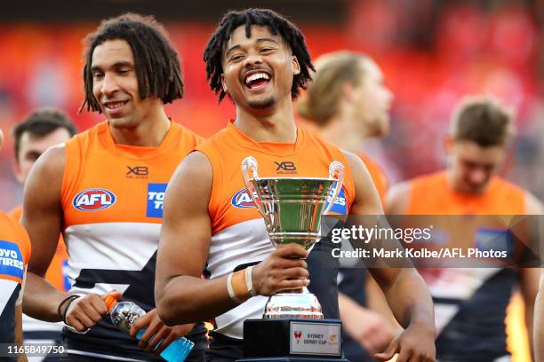 Connor Idun of the Giants shares a laugh with his team mates as he leaves the field holding the Sydney Derby Cup after victory during the round 20...
