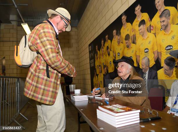 Umpire John Holder and artist Paul Trevillion at a book signing of 'You are the Umpire' during day two of the First Specsavers Test Match between...