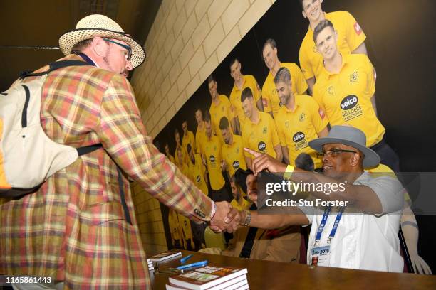 Umpire John Holder and artist Paul Trevillion at a book signing of 'You are the Umpire' during day two of the First Specsavers Test Match between...