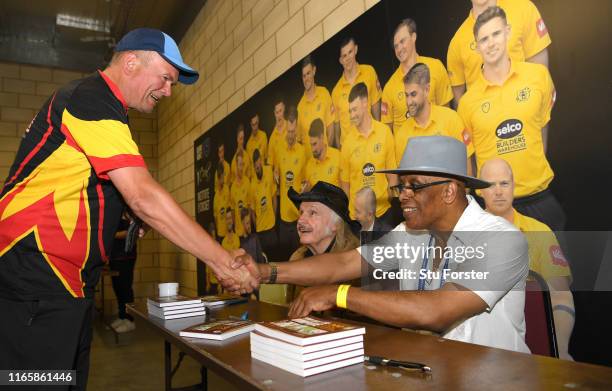 Umpire John Holder and artist Paul Trevillion at a book signing of 'You are the Umpire' during day two of the First Specsavers Test Match between...