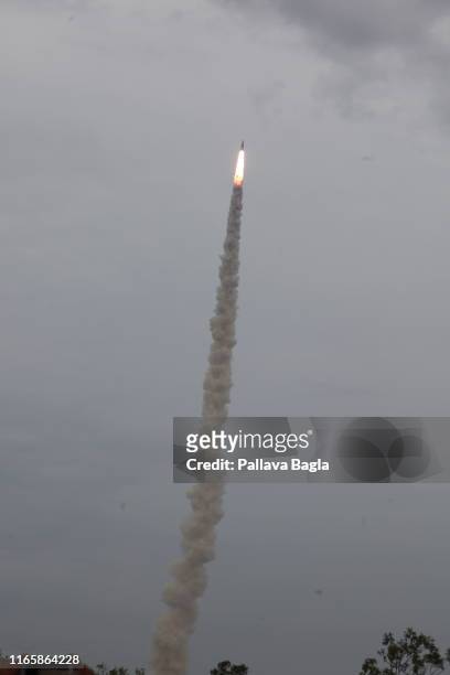 The moon bound streaks through the sky leaving a smoke trail. The Indian space agency successfully lofted its second mission to the moon named...