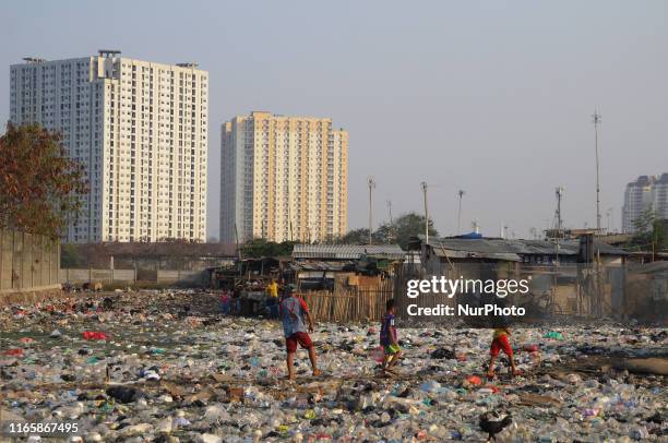 Children crossing the rubbish heap to the playground in the slums on the edge of the city precisely in the Penjaringan area, in September 2019. The...