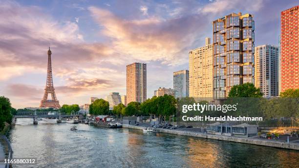 city skyline along seine river with eiffel tower and highrise buildings at front de seine, paris, france - urban areas　water front stockfoto's en -beelden