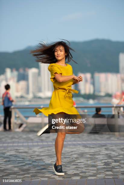 woman dancing in of joy, around at view of famous victoria harbor, hong kong cityscape - chinese dance stock pictures, royalty-free photos & images