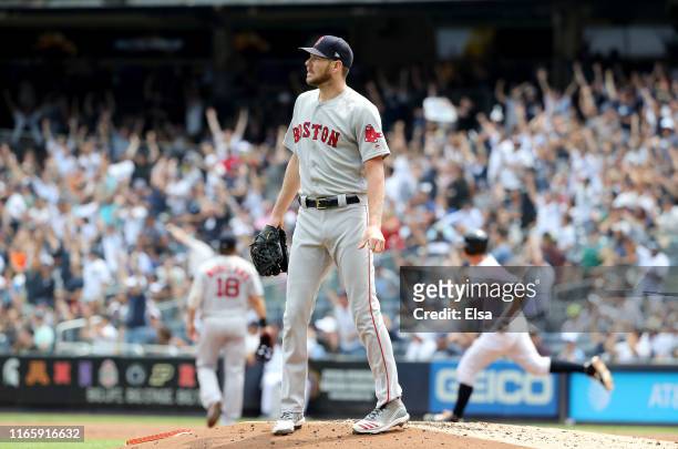 Chris Sale of the Boston Red Sox reacts as DJ LeMahieu of the New York Yankees rounds first after he hit a solo home run in the first inning during...