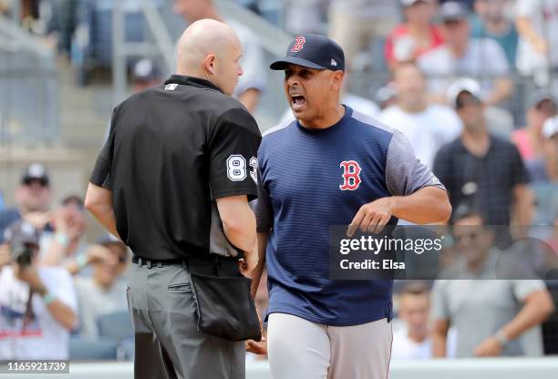 Manager Alex Cora of the Boston Red Sox argues with home plate umpire Mike Estabrook after Cora was tossed from the game in the fourth inning against...