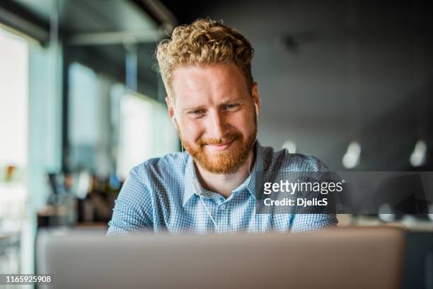 smiling young man taking an online seminar. - cafe front stock pictures, royalty-free photos & images