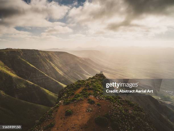 mesmerising views enjoyed by two hikers at sunset, lanzarote - lanzarote fotografías e imágenes de stock