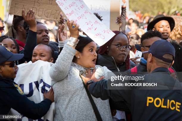 People clash with police officers as they demonstrate outside The Cape Town International Convention Centre, where the World Economic Forum Africa...