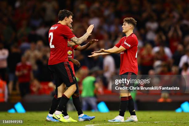 Daniel James of Manchester United celebrates with his teammates Victor Lindelof and Angel Gomes after scoring the winning penalty in the shootout...