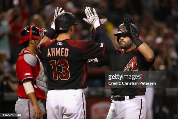 Alex Avila of the Arizona Diamondbacks high fives Nick Ahmed after hitting a two-run home run against the Washington Nationals during the fifth...